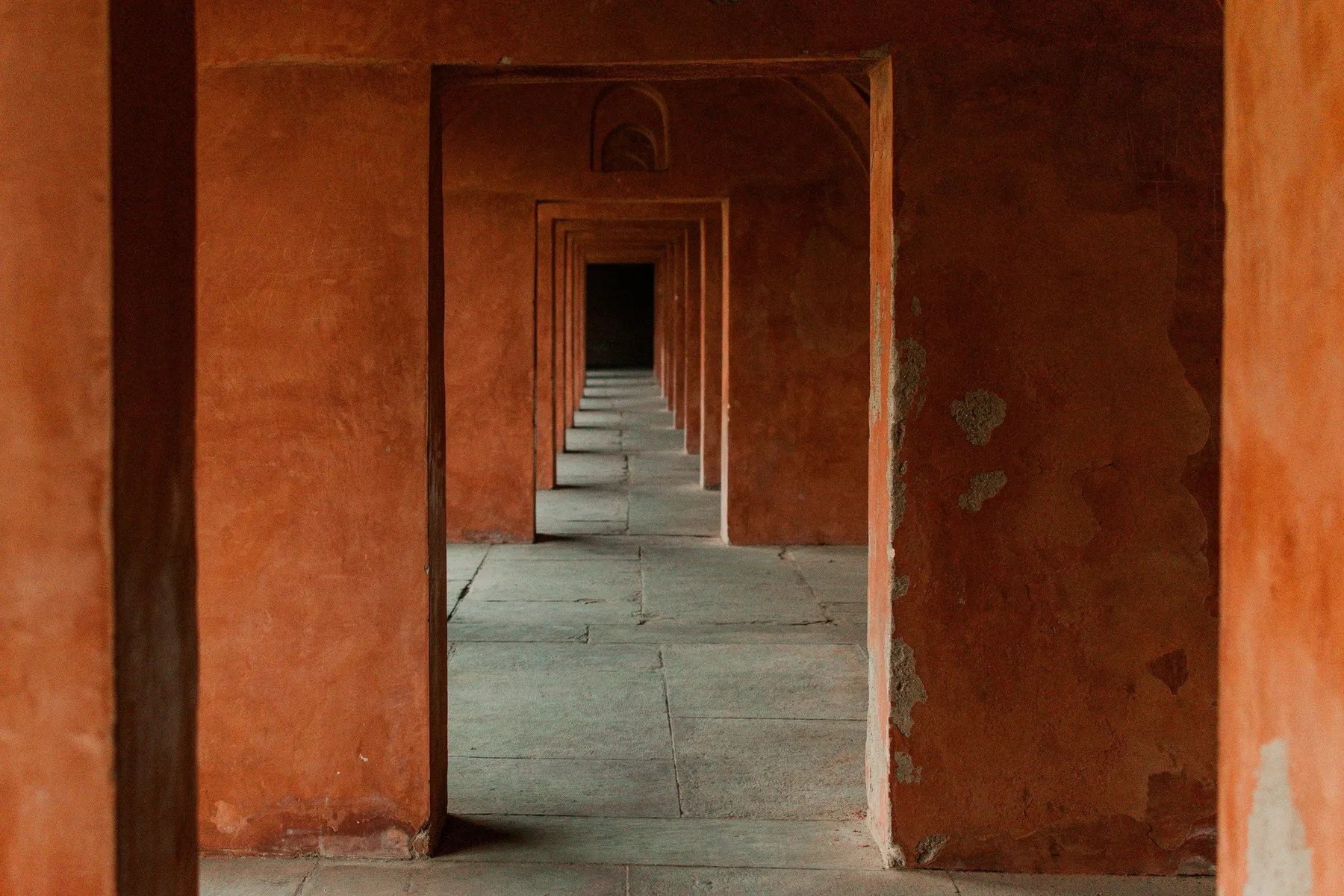 A long terracotta corridor of arches