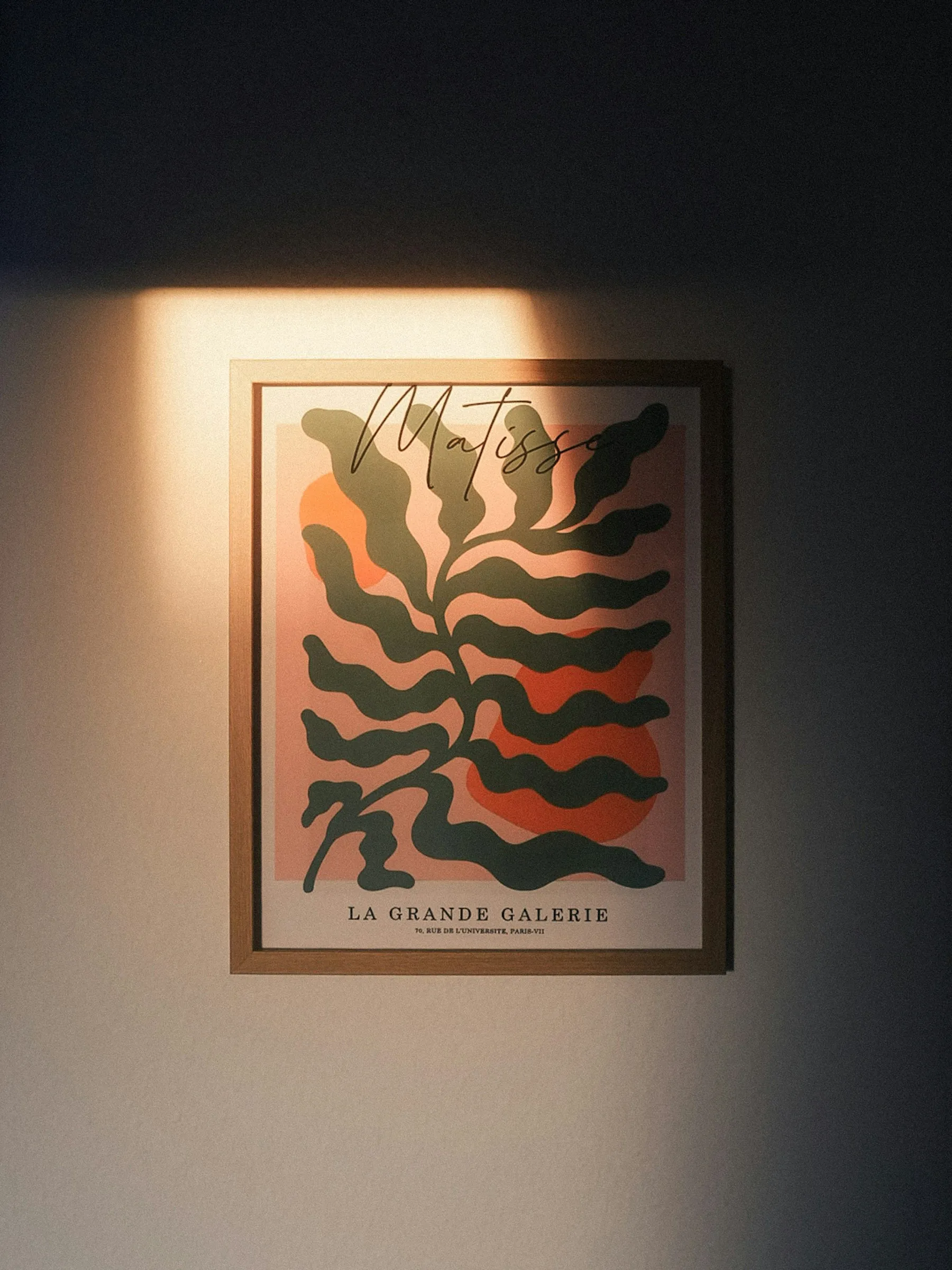 An abstract art print on a wall, lit by a sunbeam